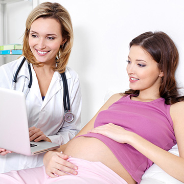 08_pregnant-young-woman-her-doctor-looking-laptop-indoors