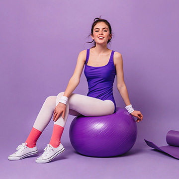 09_woman-bright-fitness-bodysuit-sits-fitball-wall-yoga-mat-pink-water-bottle-dumbbell